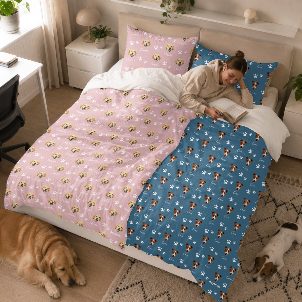 Frau liest im Bett mit rosa und blauer Foto-und-Name-Bettwäsche, Hunde am Boden