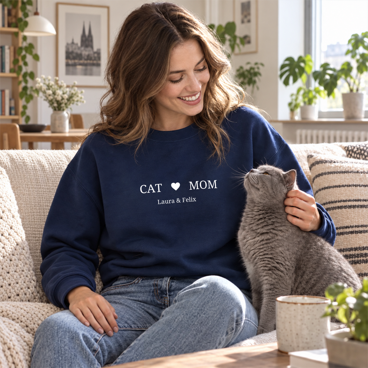 Frau streichelt graue Katze im marineblauen Cat-Mom-Sweater mit Herz und Namen