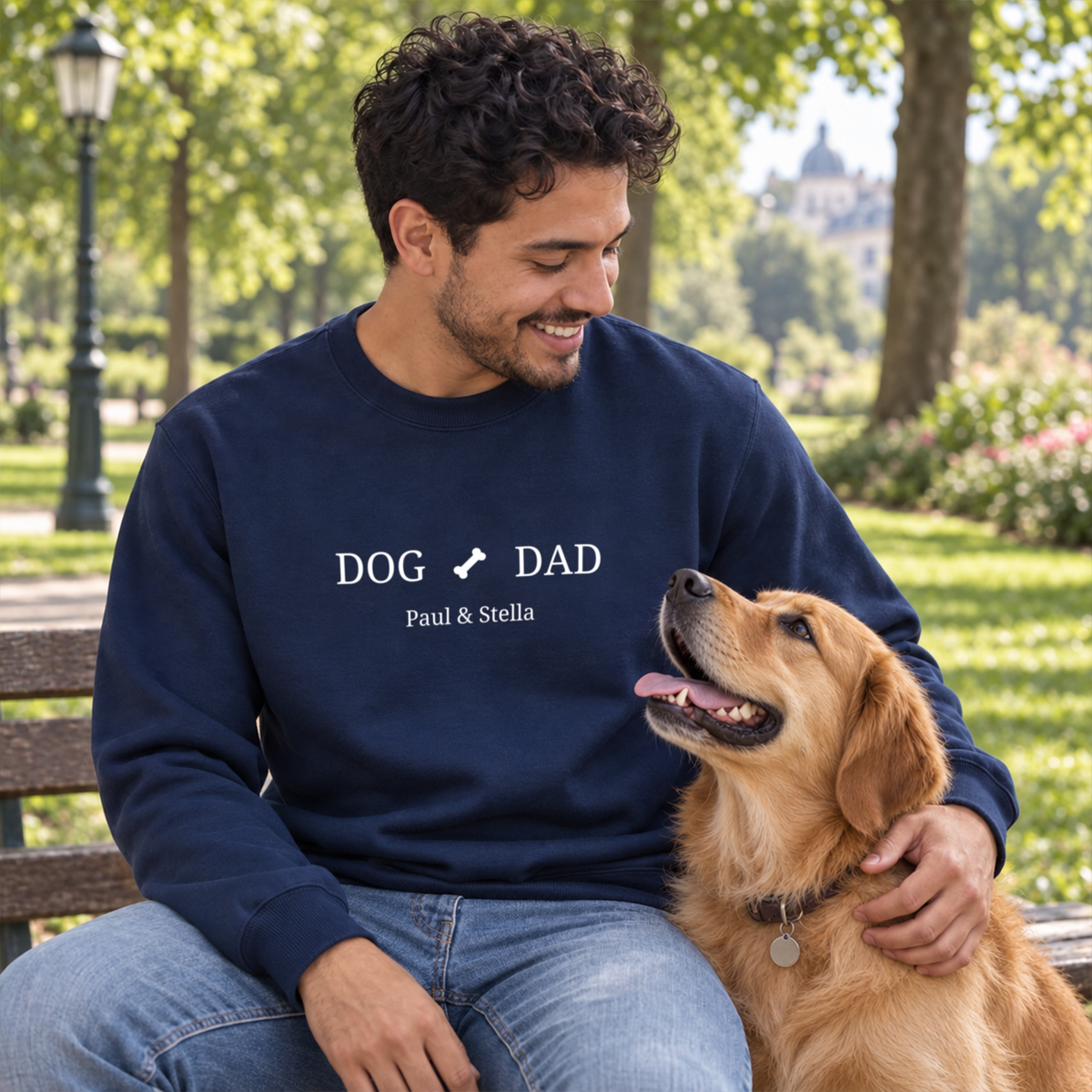 Lachender Mann mit Retriever im marineblauen Dog-Dad-Sweater mit Knochen-Motiv und Namen