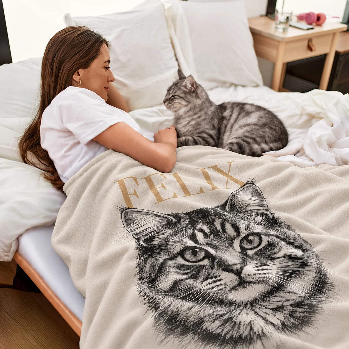 Frau kuschelt im Bett mit ihrer getigerten Katze unter der Retro-Katze-Decke