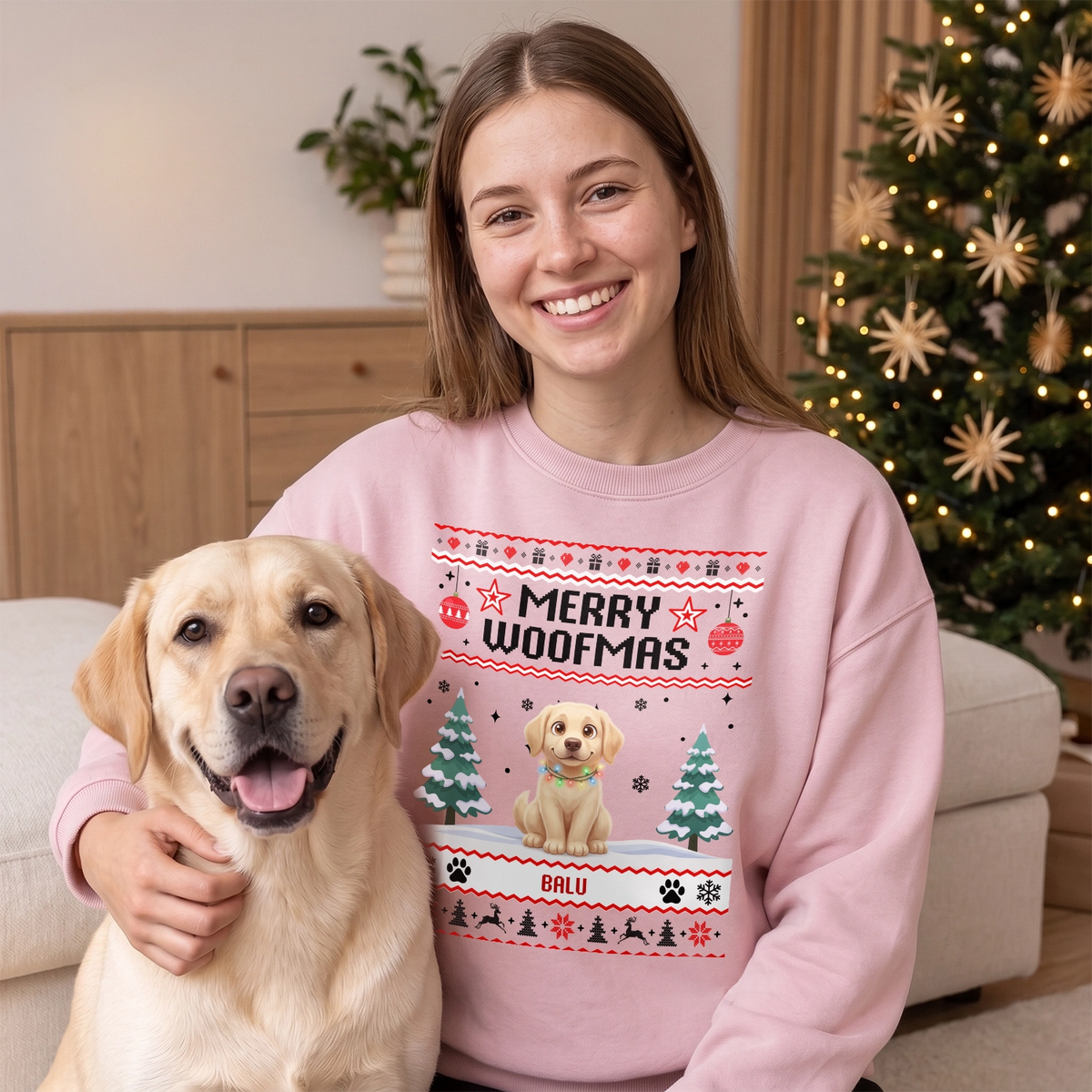 Frau im rosa Weihnachtspullover mit Cartoon ihres Labradors neben ihrem Hund